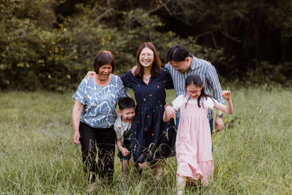 Parents and children walking through Riverhead Forest during a whimsical sunset session – natural family photos in West Auckland.