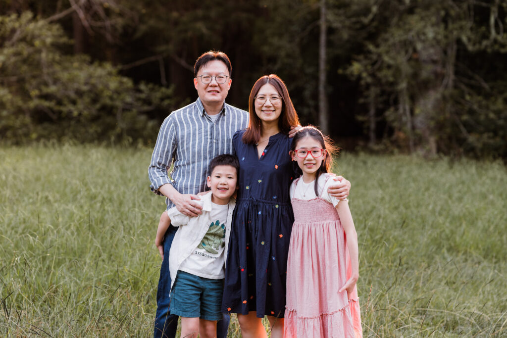 Family of four enjoying the golden light in Riverhead Forest – candid West Auckland family photography.