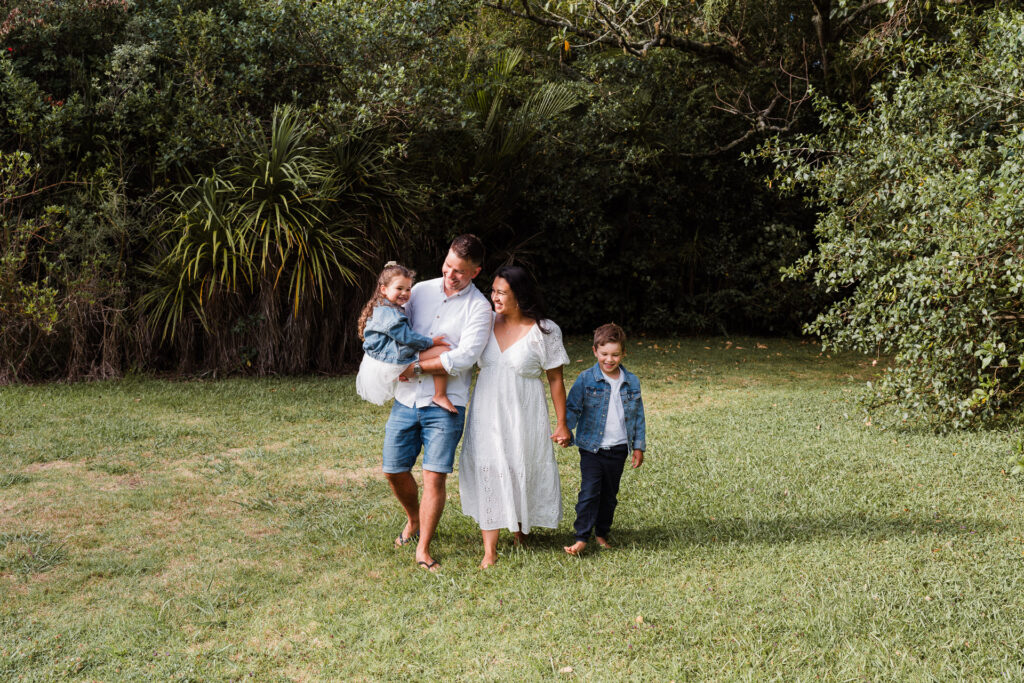 Close-up of a family’s bare feet walking across the wet sand at Cornwallis Beach, West Auckland family photography.