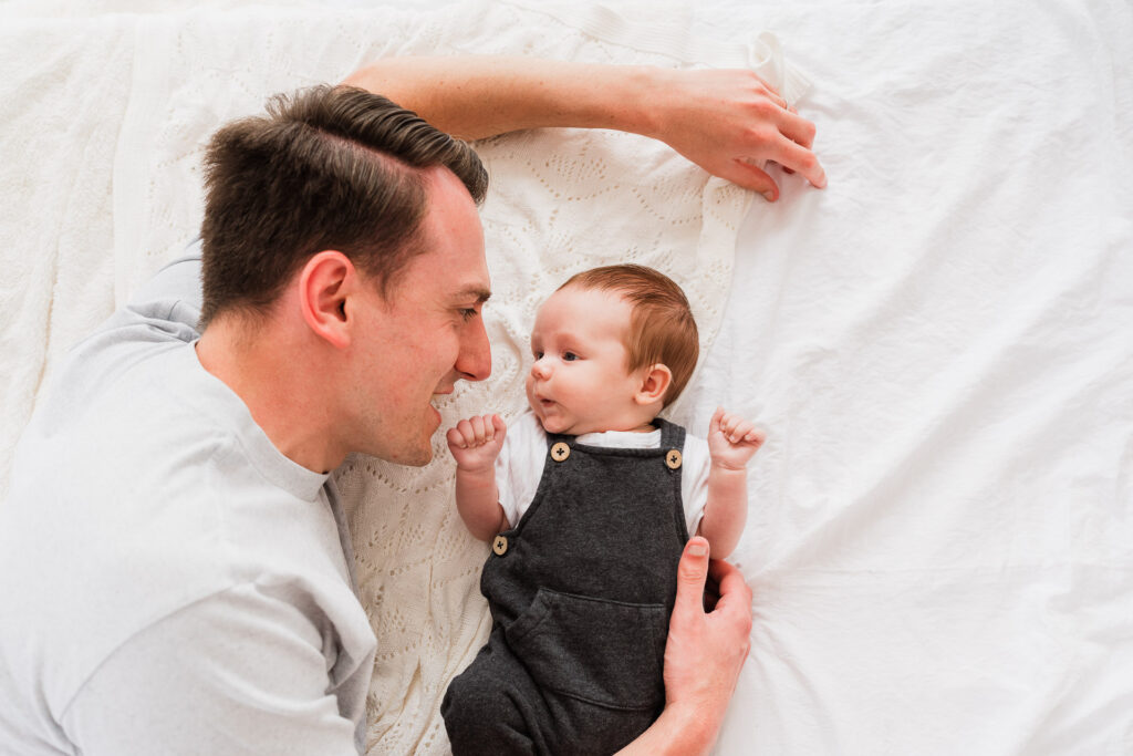Dad gently cuddling newborn son during a studio session at Wonderstudio, West Auckland family photographers.