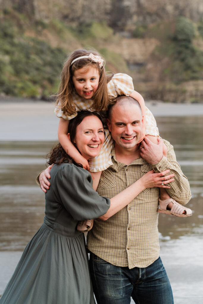 Family tickle fight captured in soft light on the sand during a Wonderferris beach mini session.