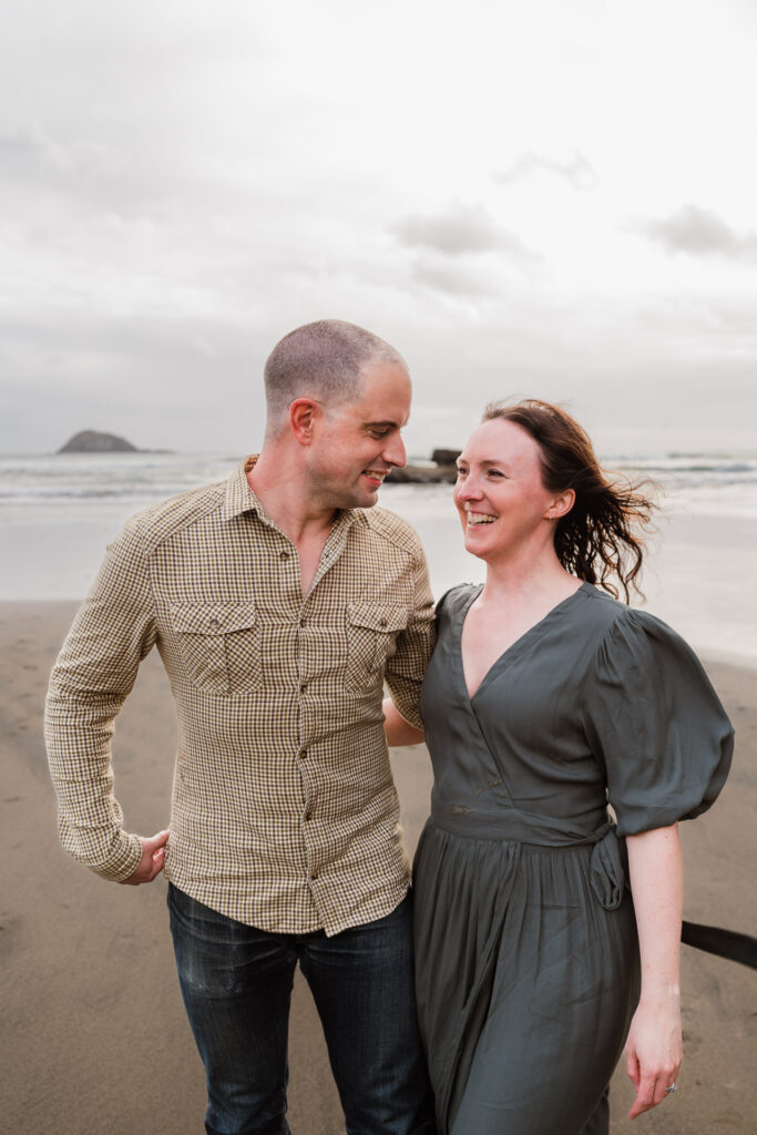 Couple cuddling in golden light during an Auckland beach mini shoot at Maori Bay by Wonderferris.