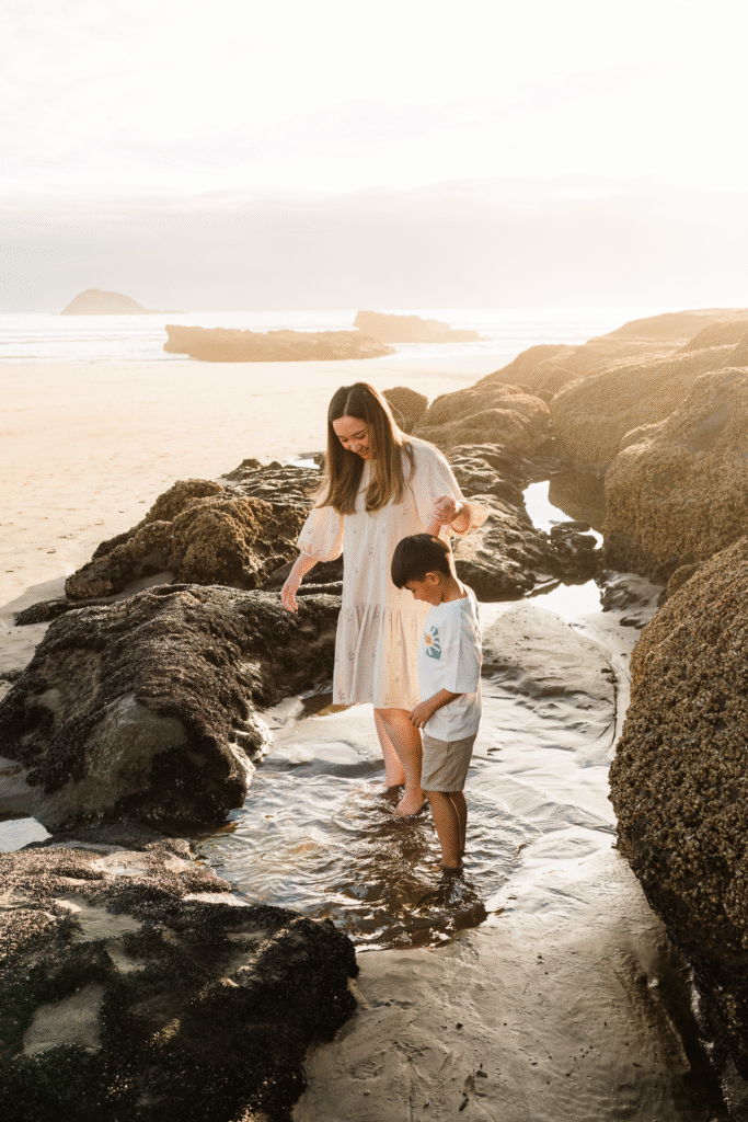 Sweet moment between mum and son at Muriwai Beach during a golden hour mini session, captured by Auckland family photographer Wonderferris.