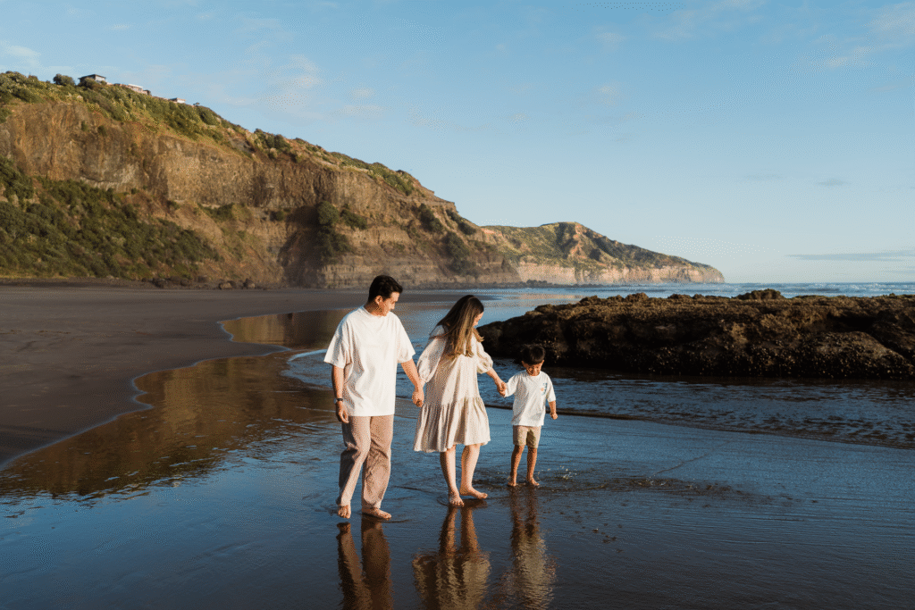 Joyful walking shot from an Auckland beach mini session, showing connection and movement.