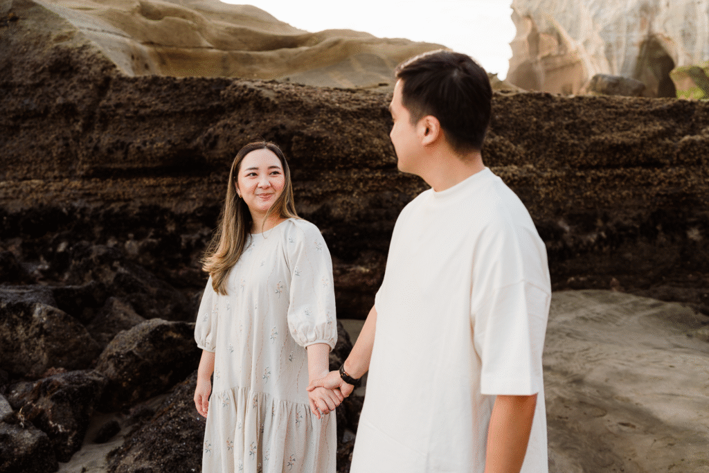 Candid image of a couple laughing together on the sand during a mini session with Wonderferris.