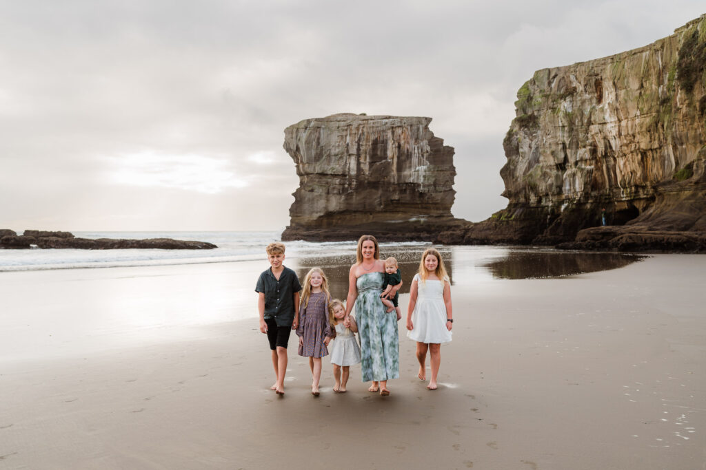 Golden hour beach walk with mother and kids hand-in-hand at Maori Bay, captured by Wonderferris.