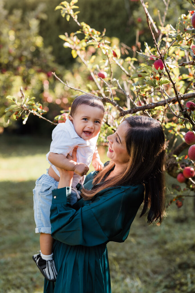 Warm portrait of mum hugging her son in an orchard during a NorthWest Auckland mini session by Wonderferris.