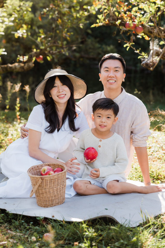 Golden hour portrait of a family surrounded by orchard greenery, Wonderferris mini photography.