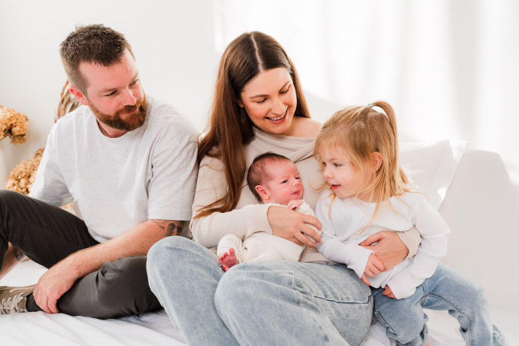 family cuddling in studio for newborn photoshoot in kumeu auckland