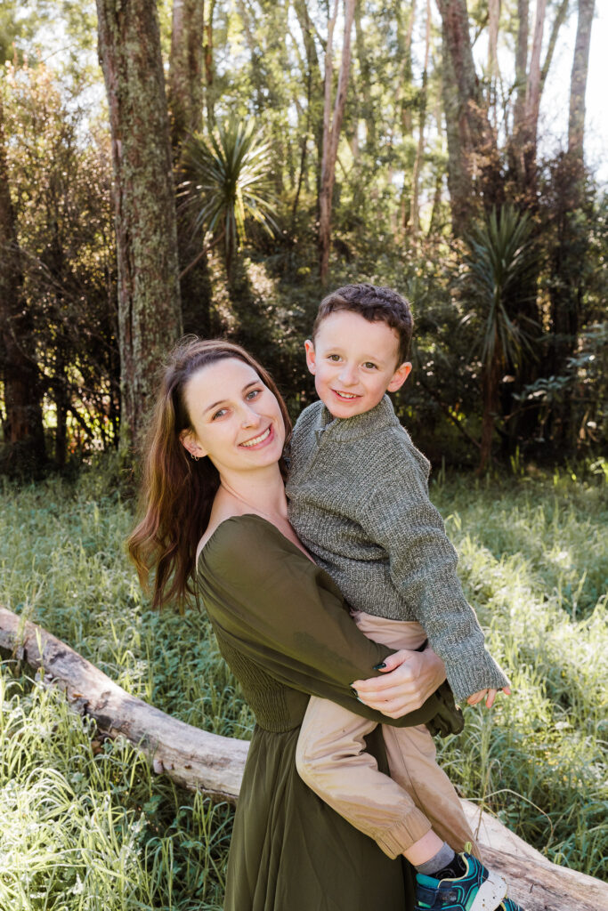 Tender moment between mum and kids, sitting among tall trees in Riverhead Forest — photographed by Wonderferris