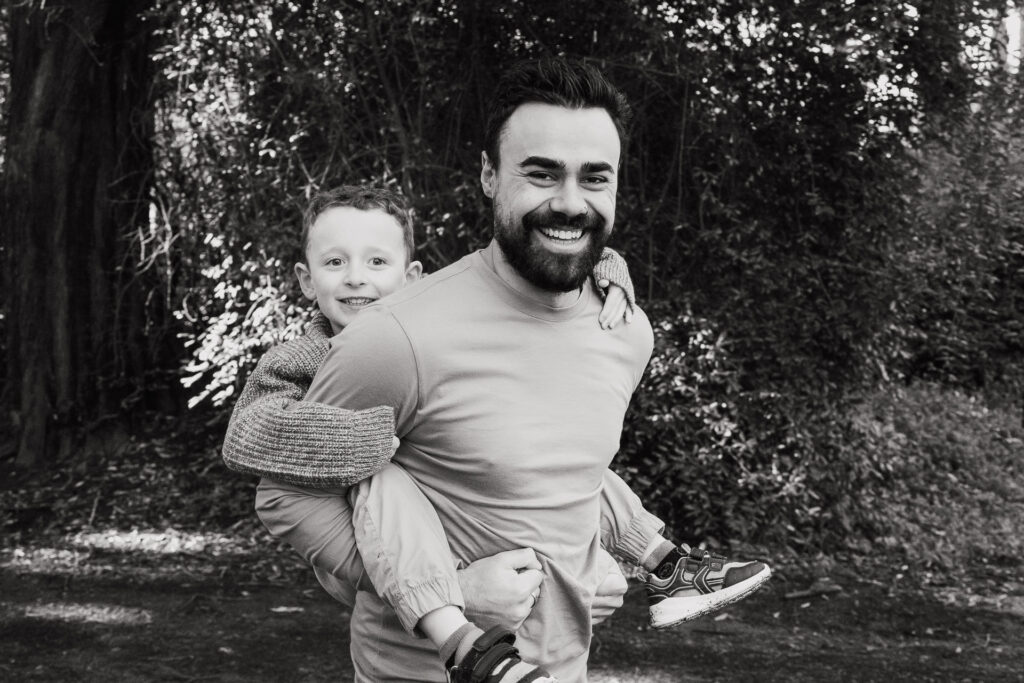 Stepdad holding hands with the kids, walking through forest trails — outdoor family session in Auckland