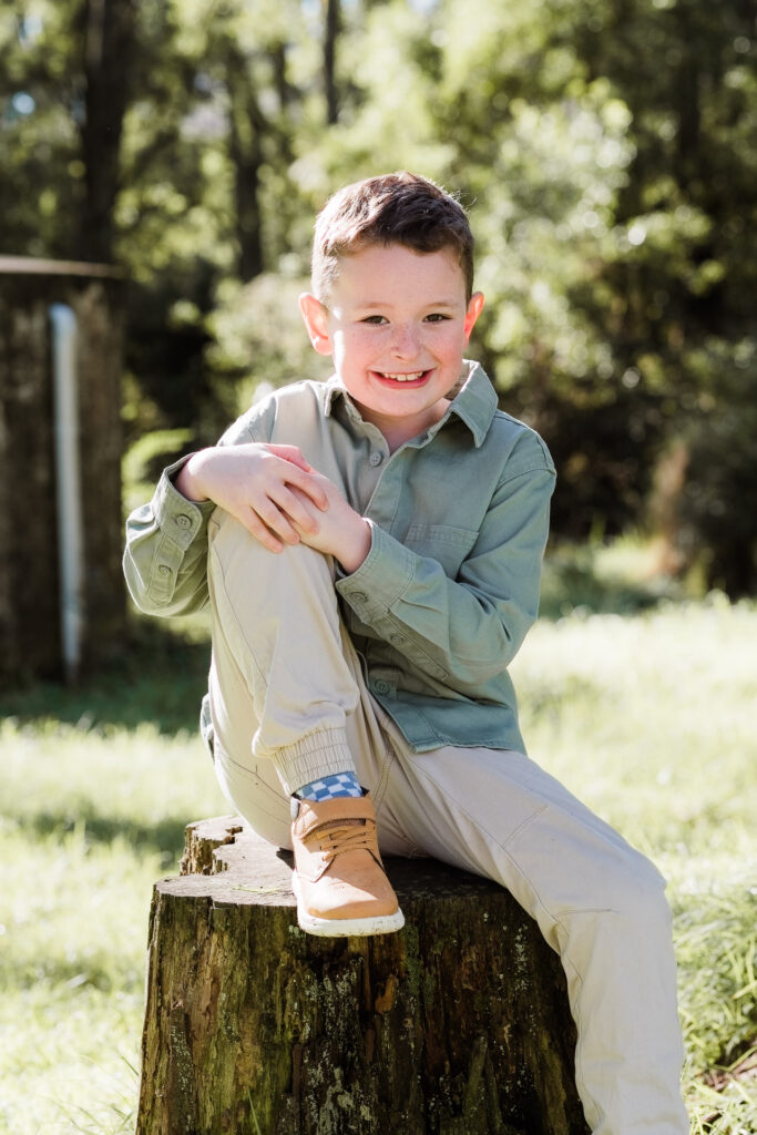 Young boy standing on a forest path surrounded by trees, looking confident — Auckland family photography session